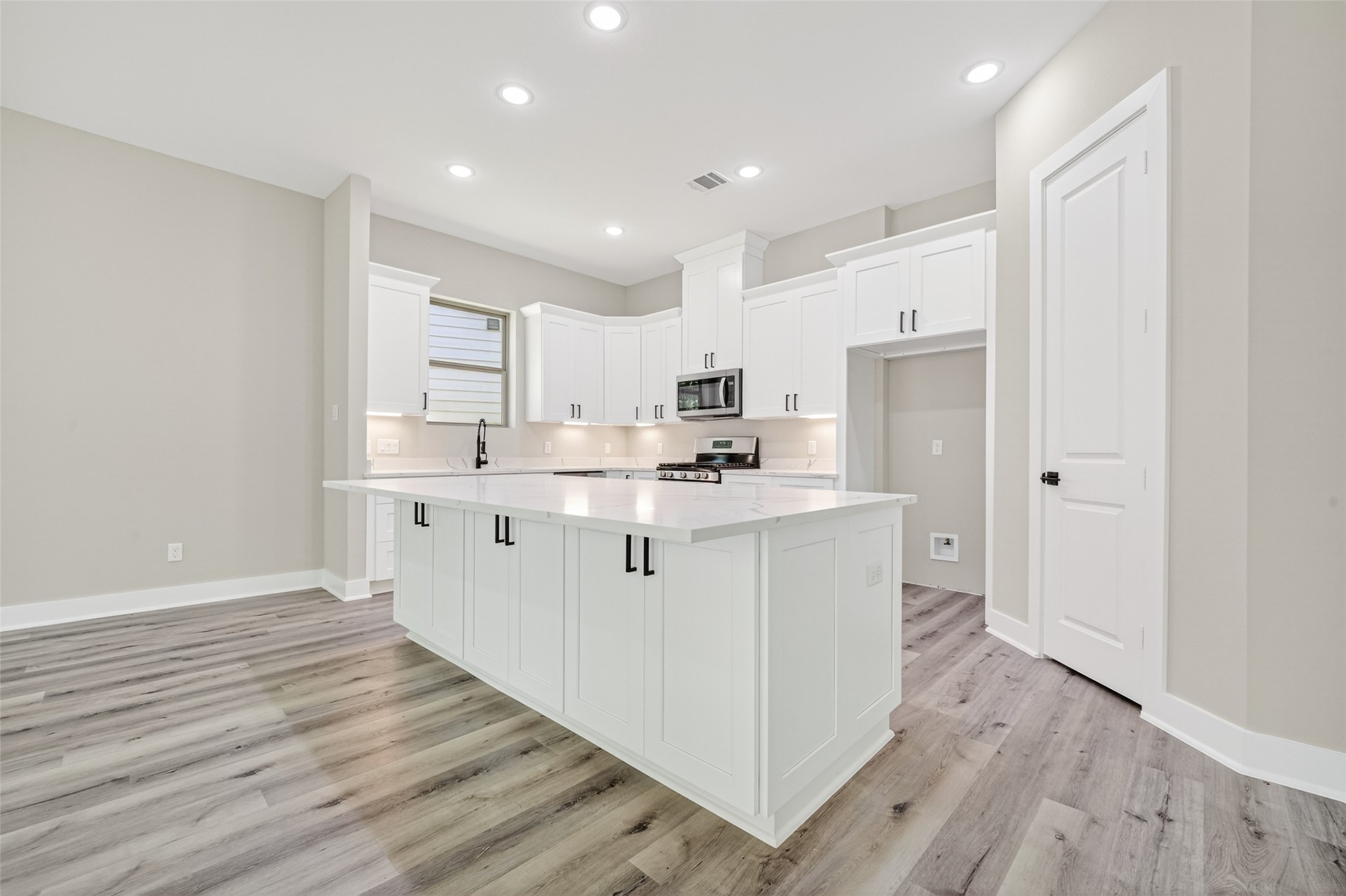 4906 Wunder Way Houston, TX 77069 - Photo 8 of 44 a kitchen with white cabinets appliances and wooden floor