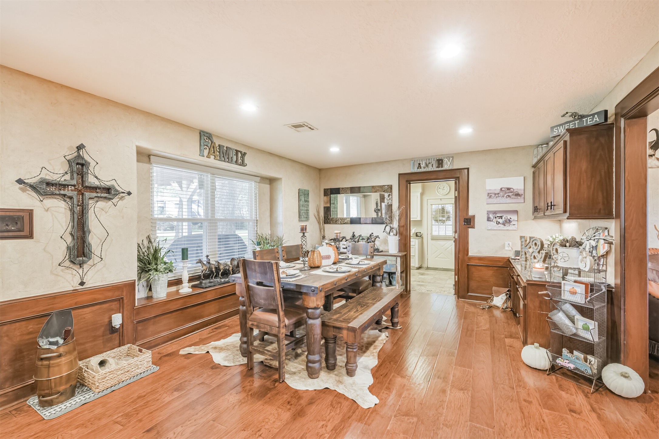307 West Hufsmith Road Tomball, TX 77375 - Photo 11 of 44 Charming dining area with warm wood floors, rustic decor, and ample natural light, perfect for family gatherings.
