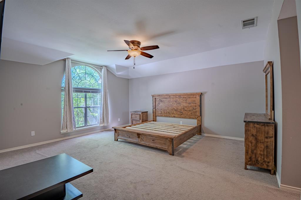921 Carnegie Court Allen, TX 75002 - Photo 18 of 33 a spacious bedroom with a bed and a window