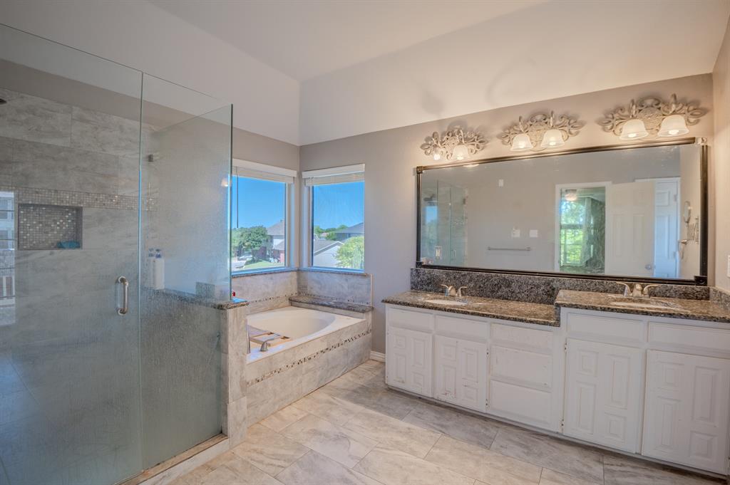 921 Carnegie Court Allen, TX 75002 - Photo 21 of 33 a bathroom with a granite countertop tub a double vanity sink and mirror