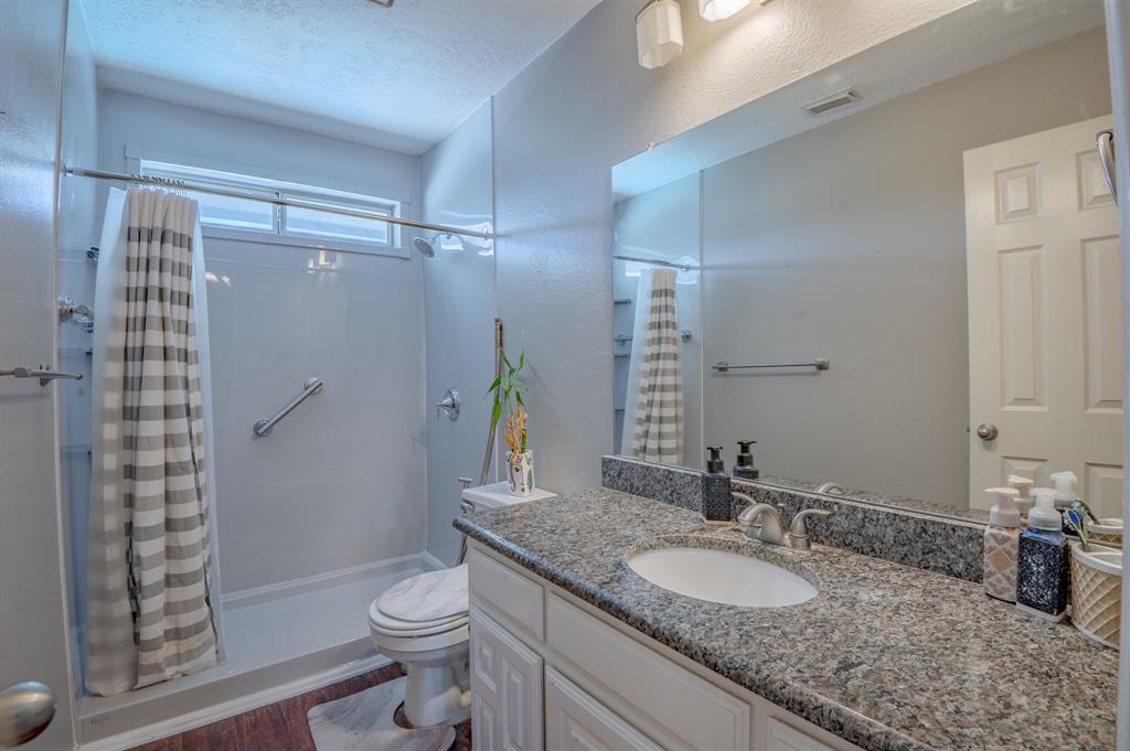 921 Carnegie Court Allen, TX 75002 - Photo 25 of 33 a bathroom with a granite countertop sink toilet and shower