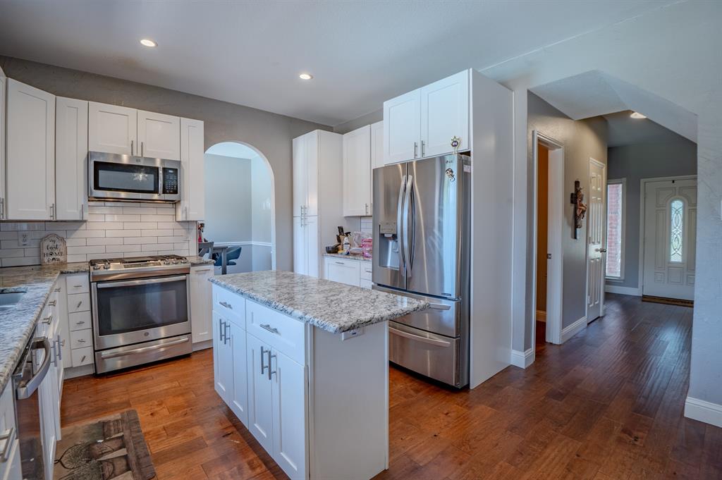921 Carnegie Court Allen, TX 75002 - Photo 7 of 33 a kitchen with stainless steel appliances white cabinets and wooden floor