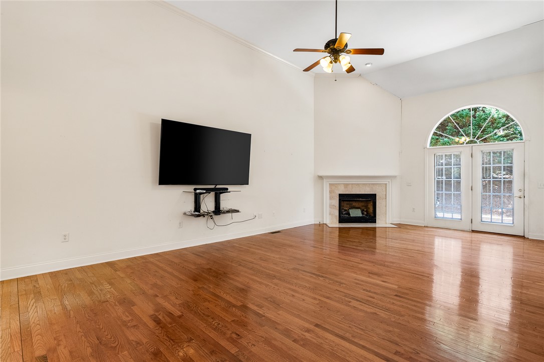 135 Sunset Bay Boulevard Seneca, SC 29672 - Photo 10 of 50 A spacious living room features vaulted ceilings, rich hardwood floors, and a welcoming fireplace.
