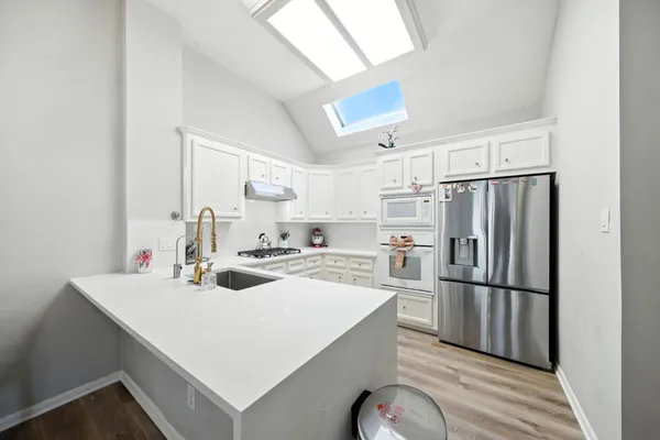 a kitchen with a refrigerator a sink and cabinets