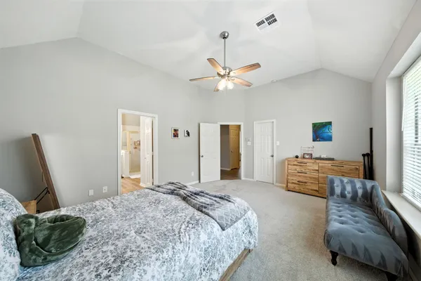 a bedroom with a bed and dresser with mirror