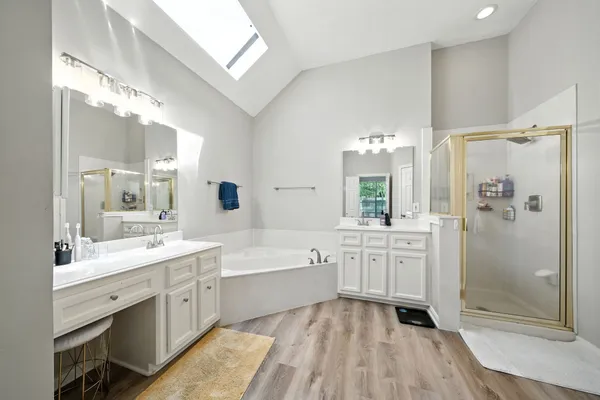 a bathroom with a tub sink shower and mirror