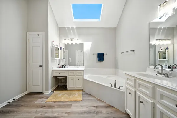 a spacious bathroom with a tub double sink and mirror