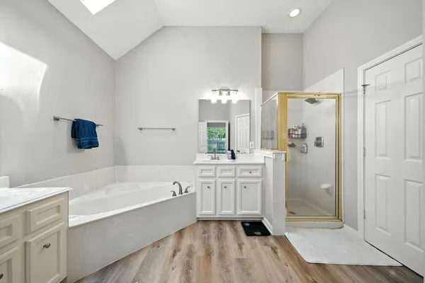 a spacious bathroom with a tub shower a sink and a mirror