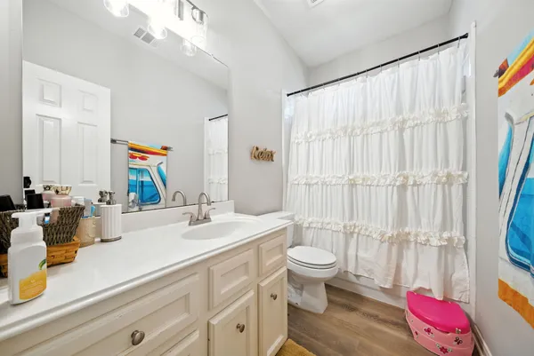 a bathroom with a sink vanity mirror and toilet