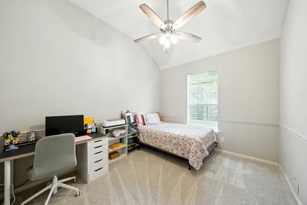 a bedroom with a bed window and a desk