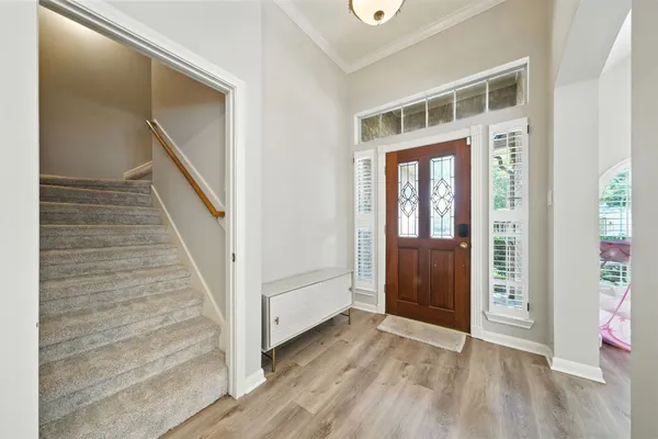 a view of a hallway with wooden floor and entryway