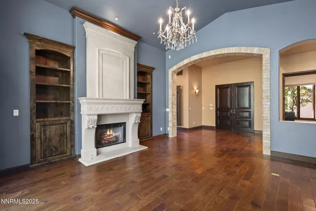 an empty room with fireplace wooden floor and windows