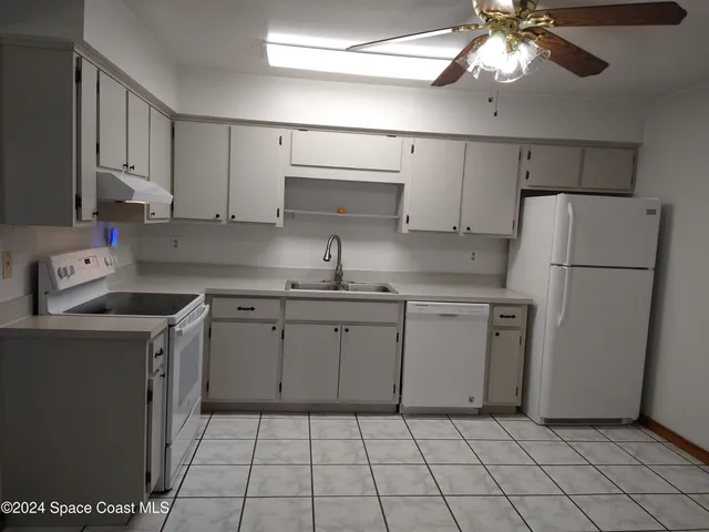 a kitchen with a stove a refrigerator and a sink