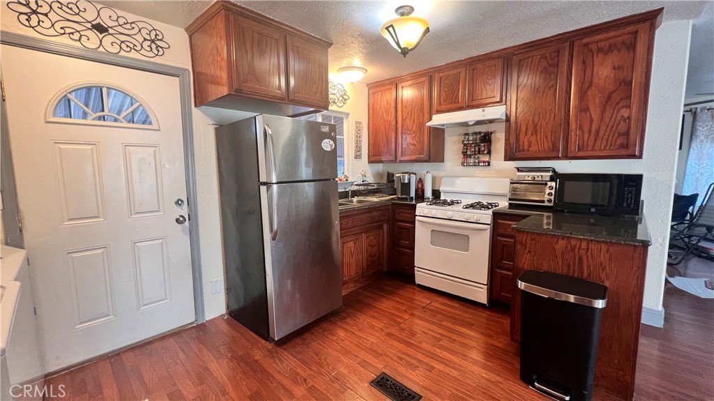 2135 Nord Avenue, Unit 33 Chico, CA 95926 - Photo 6 of 35 a kitchen with granite countertop wooden floors stainless steel appliances and cabinets