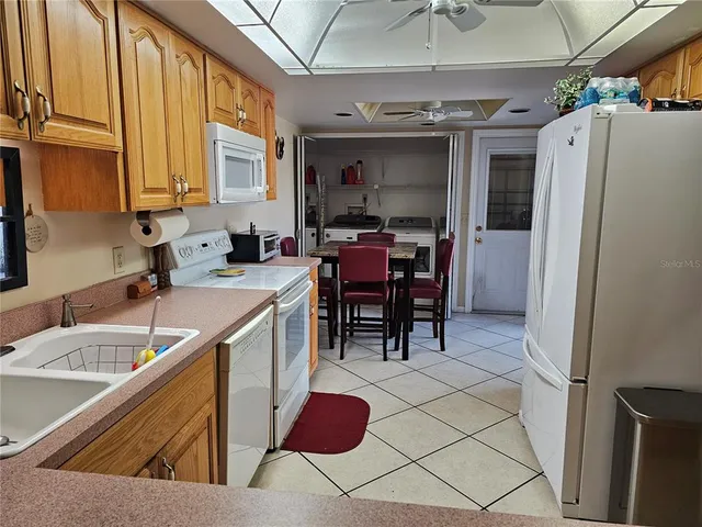 a view of kitchen with stainless steel appliances granite countertop sink and refrigerator