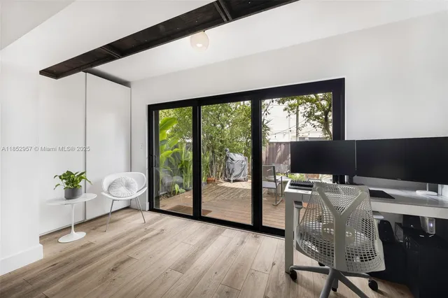 a view of a workspace with furniture and a window