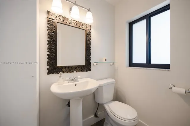 a bathroom with a toilet sink and mirror