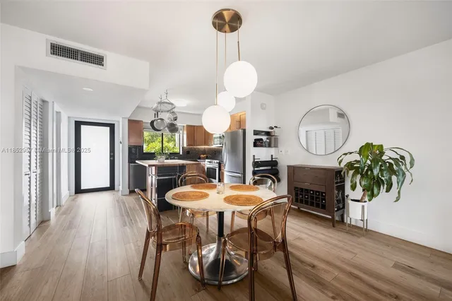 a view of a dining room with furniture a chandelier and wooden floor