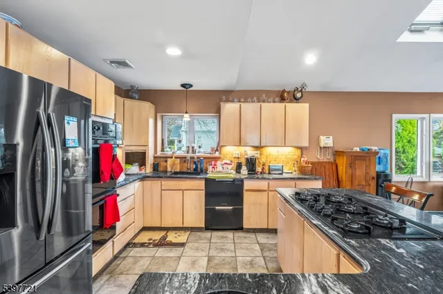 a kitchen with stainless steel appliances granite countertop a refrigerator stove and sink