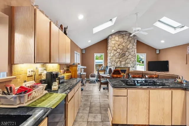 a kitchen with stainless steel appliances kitchen island granite countertop a stove and white cabinets
