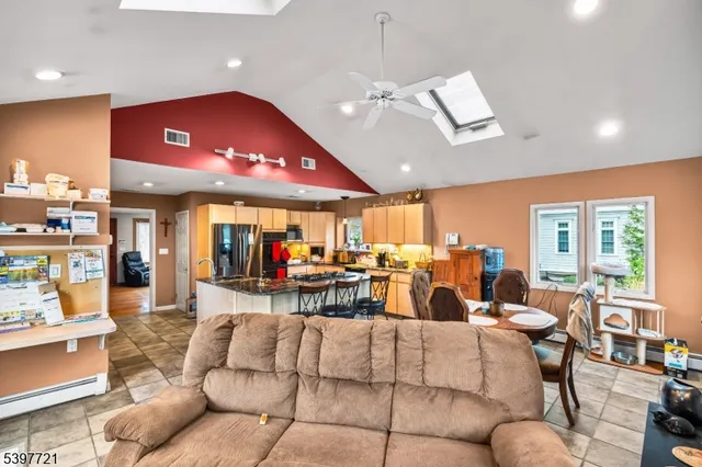 a living room with furniture a large window and stainless steel appliances