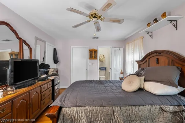 a bedroom with furniture a flat screen tv and a chandelier