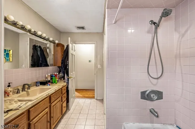 a bathroom with a double vanity sink a toilet a mirror and shower