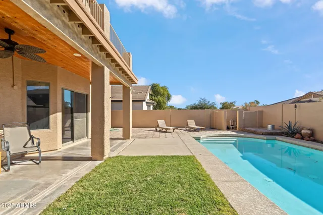 a swimming pool with yard and glass windows