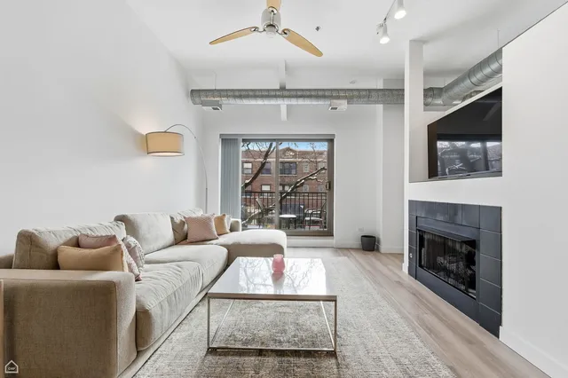 a living room with furniture a flat screen tv and a fireplace
