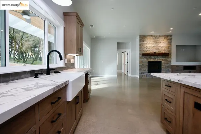 a spacious bathroom with a granite countertop sink a large mirror and a bathtub