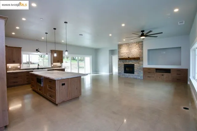 an open kitchen with granite countertop a stove oven and a sink