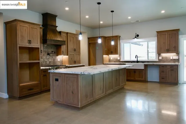a kitchen with stainless steel appliances granite countertop a sink a stove and a refrigerator