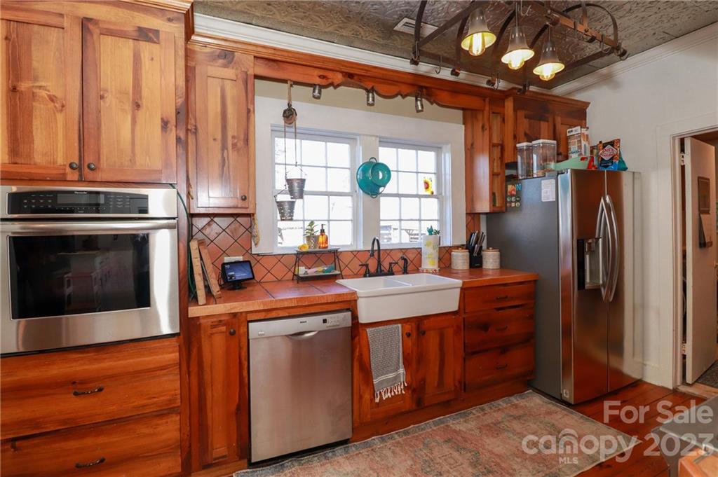 8689 Math Road Stanfield, NC 28163 - Photo 16 of 36 a kitchen with stainless steel appliances granite countertop a refrigerator a sink dishwasher a stove and white countertops with wooden floor