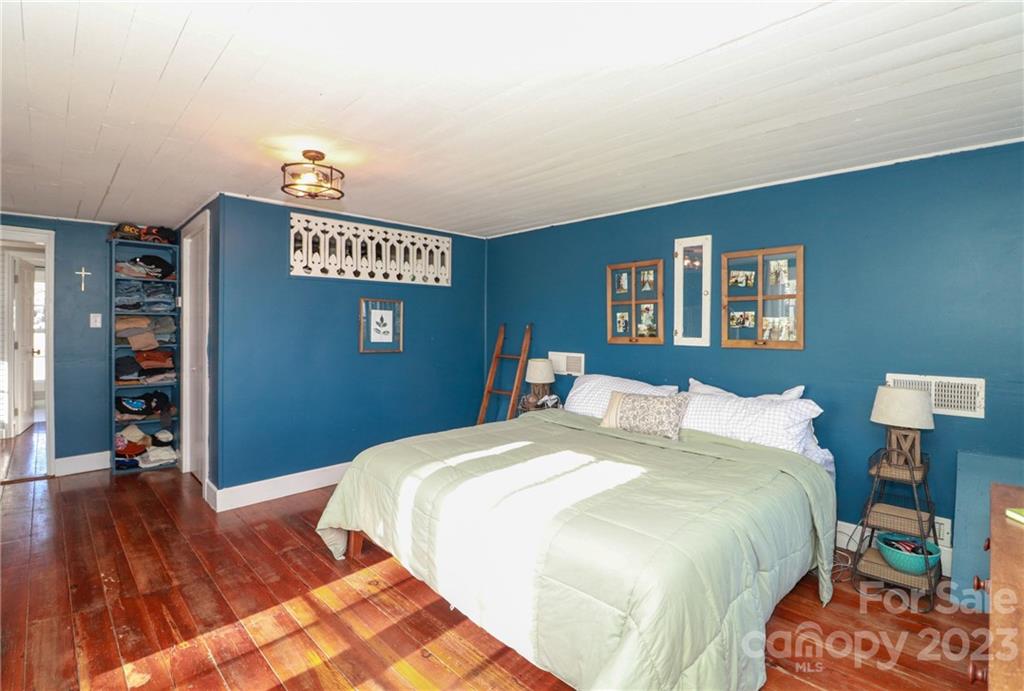 8689 Math Road Stanfield, NC 28163 - Photo 20 of 36 a bedroom with a bed and a wooden floor