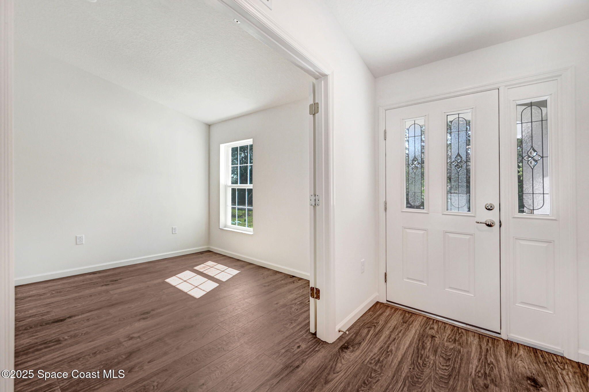 1089 Savery Road Palm Bay, FL 32908 - Photo 11 of 47 an empty room with wooden floor and windows