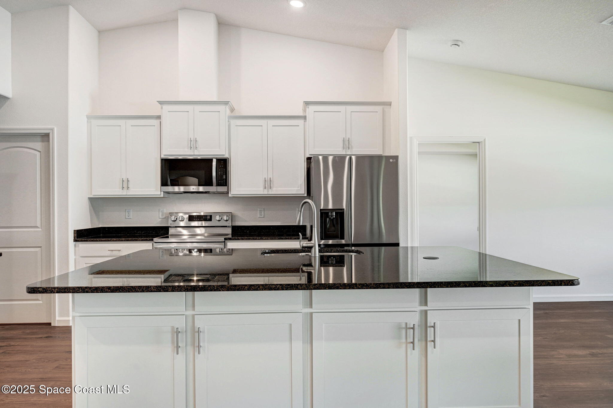 1089 Savery Road Palm Bay, FL 32908 - Photo 19 of 47 a kitchen with stainless steel appliances a sink a refrigerator a stove a microwave and cabinets