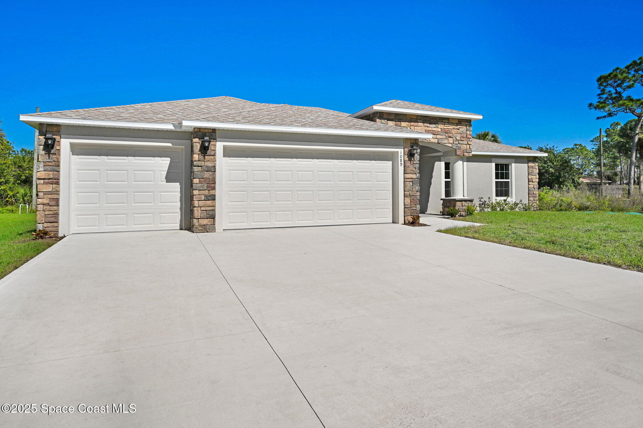 1089 Savery Road Palm Bay, FL 32908 - Photo 3 of 47 a front view of a house with a yard and garage