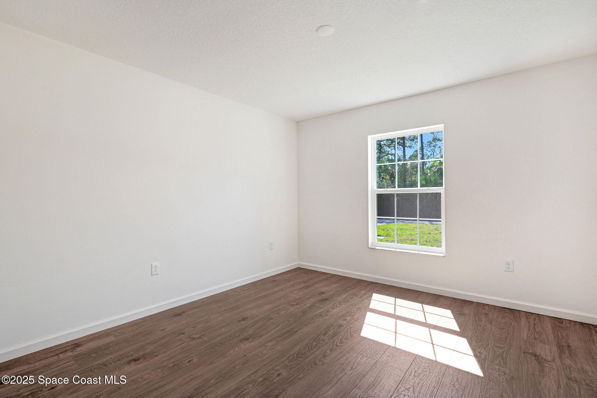 1089 Savery Road Palm Bay, FL 32908 - Photo 38 of 47 an empty room with wooden floor and windows