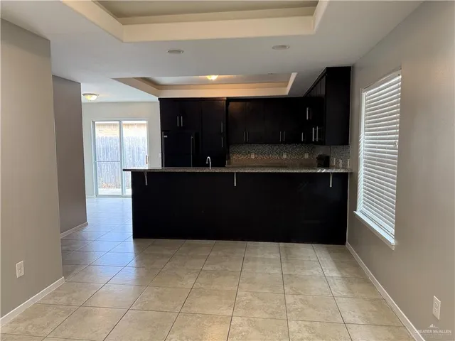 a view of kitchen with cabinets and window