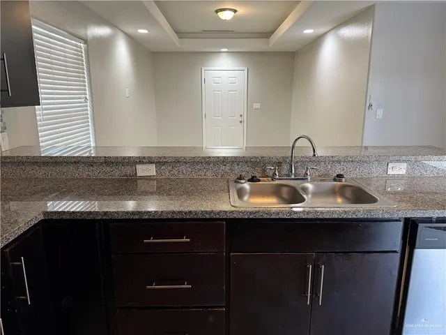 a kitchen with a sink a counter space and cabinets