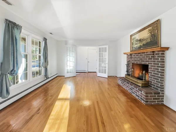 a view of empty room with wooden floor and fireplace