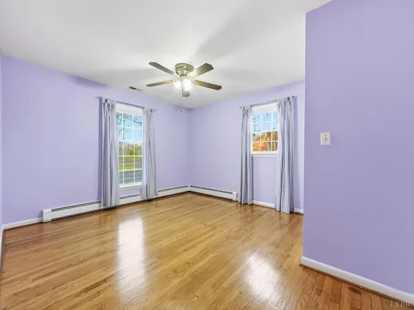 a view of empty room with wooden floor and fireplace