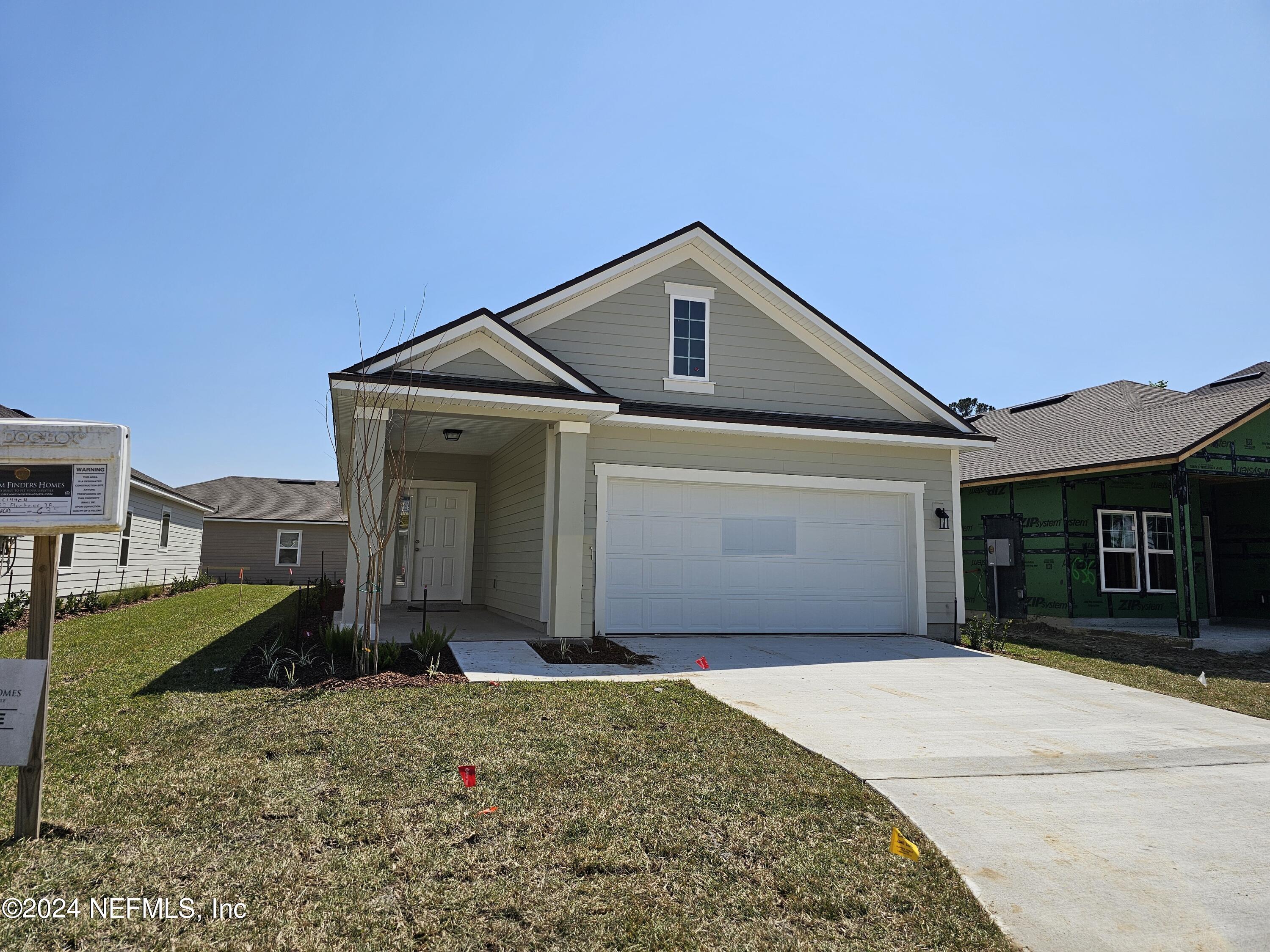 75232 Plumbago Trace Yulee, FL 32097 - Photo 1 of 79 a front view of a house with a yard and garage
