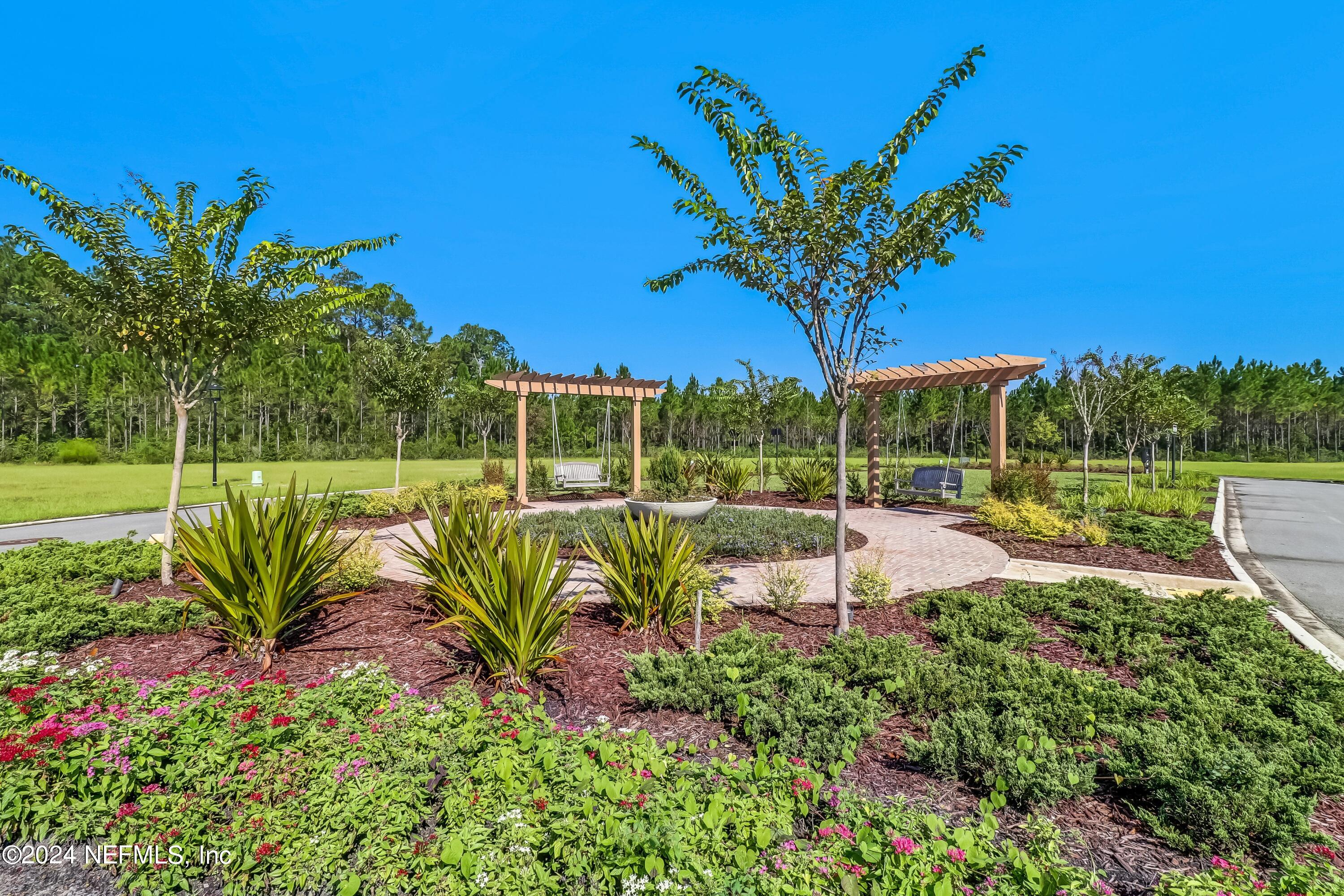 75232 Plumbago Trace Yulee, FL 32097 - Photo 18 of 79 a view of a garden with a bench