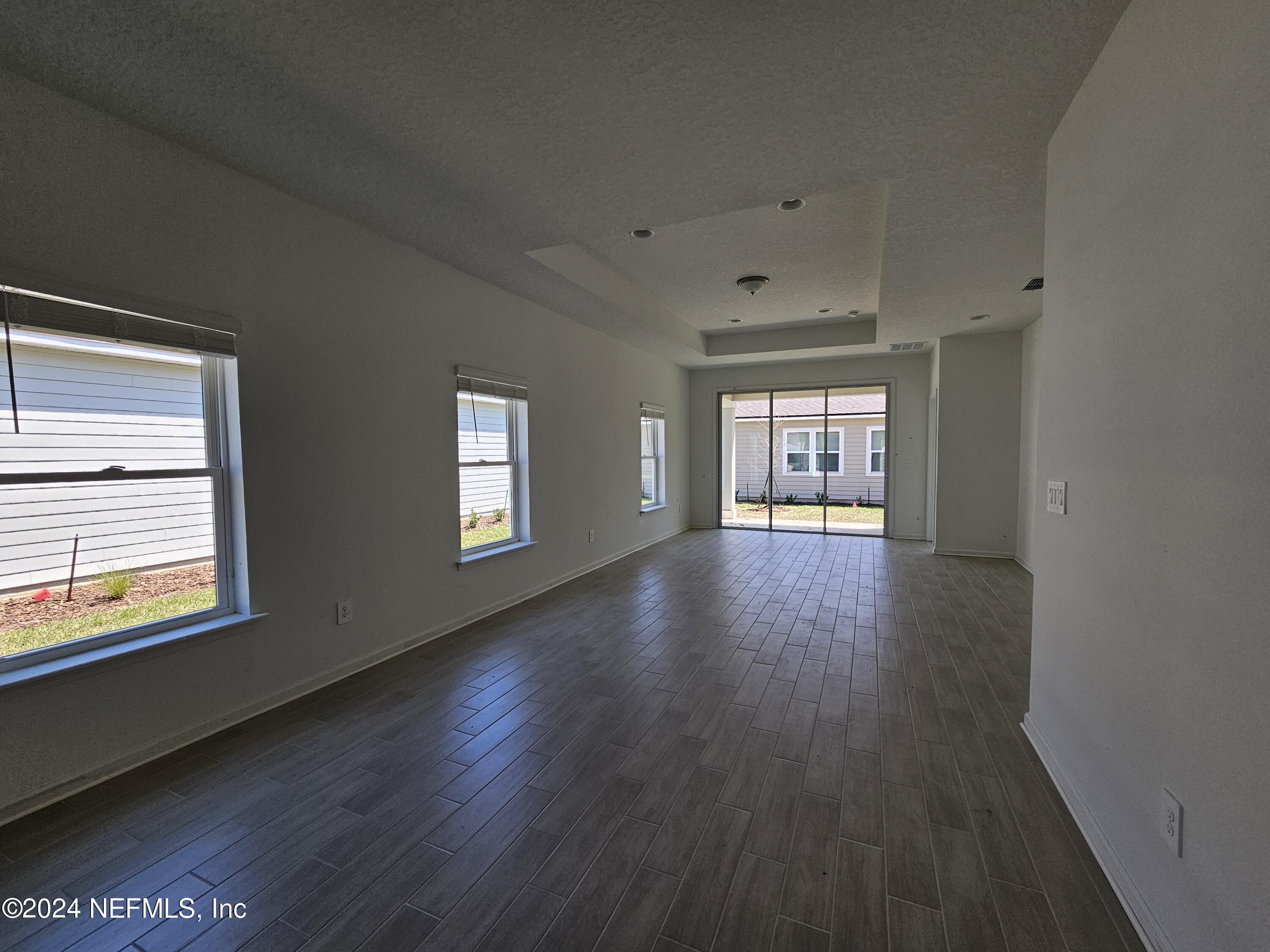 75232 Plumbago Trace Yulee, FL 32097 - Photo 6 of 79 a view of an empty room with window and wooden floor
