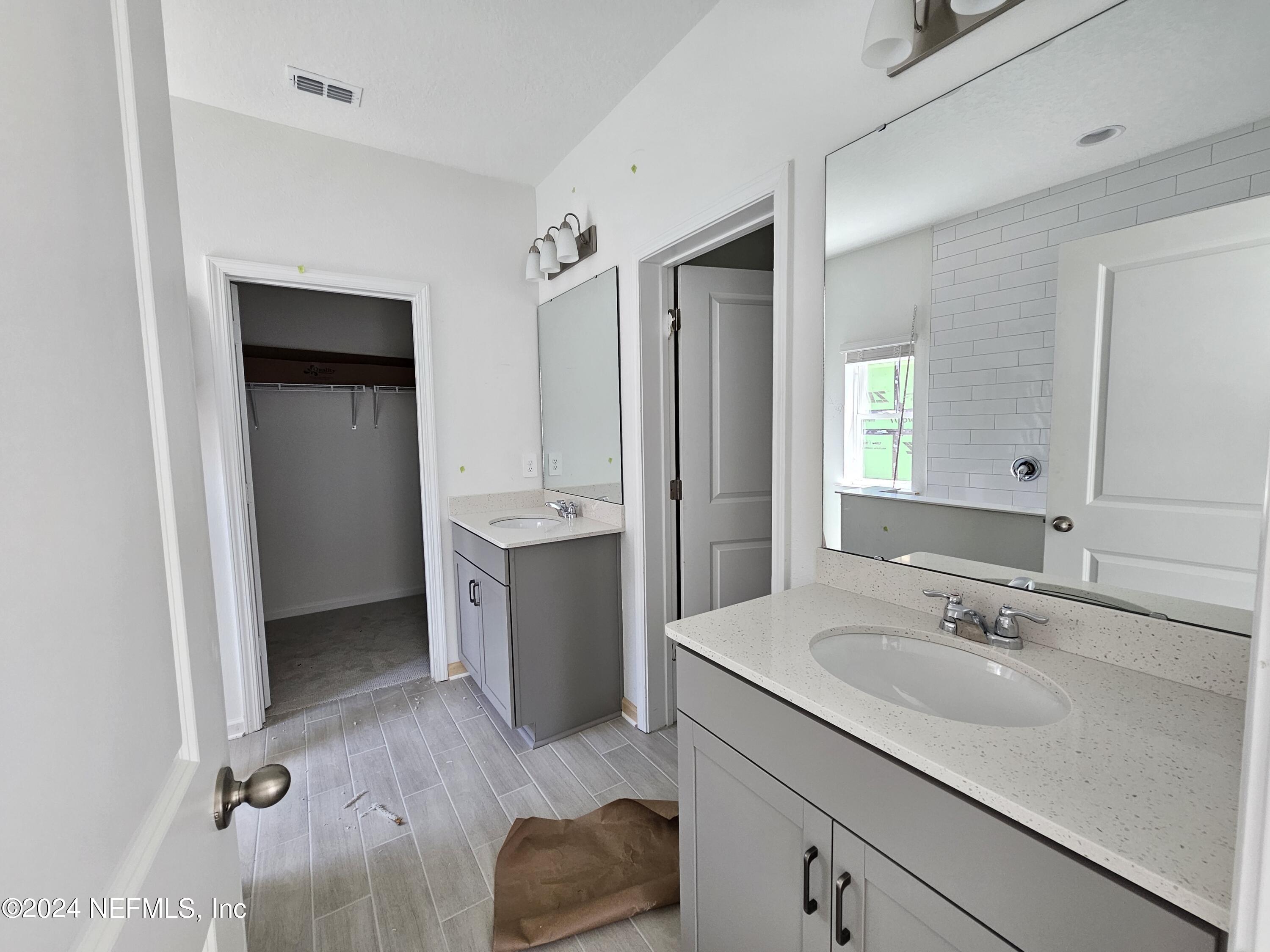 75232 Plumbago Trace Yulee, FL 32097 - Photo 9 of 79 a spacious bathroom with a double vanity sink a mirror and a bathtub