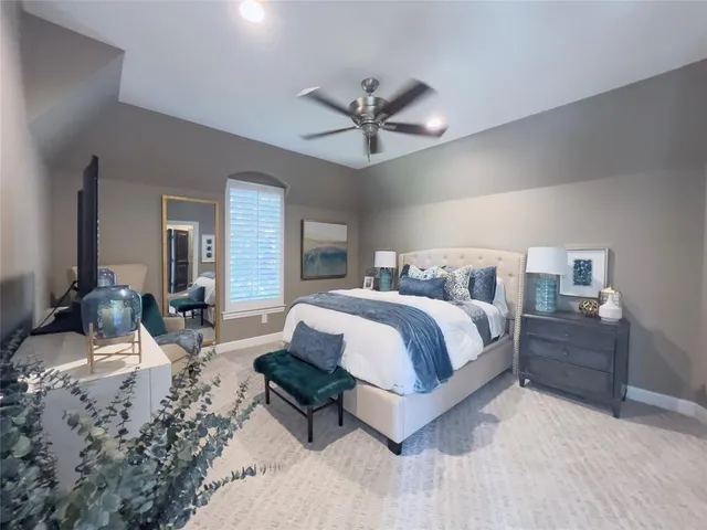 a spacious bedroom with a bed a chandelier and dresser