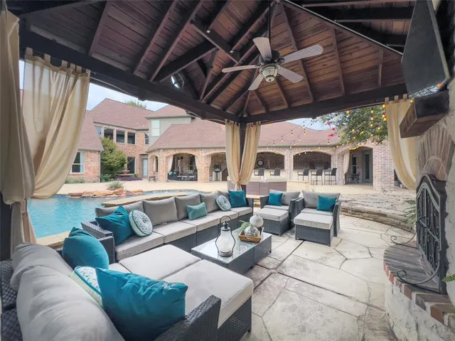 a view of a patio with couches and a large umbrella