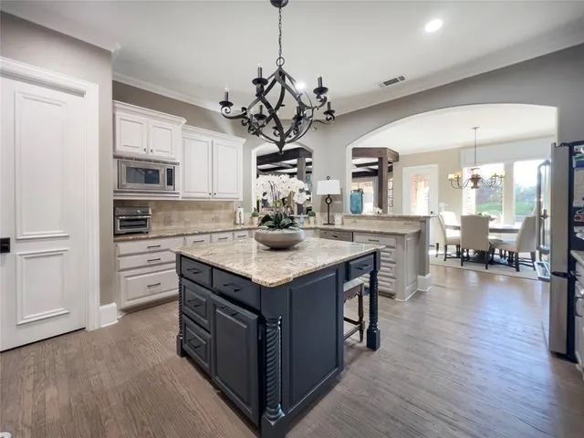 a kitchen with a center island wooden floor and a refrigerator