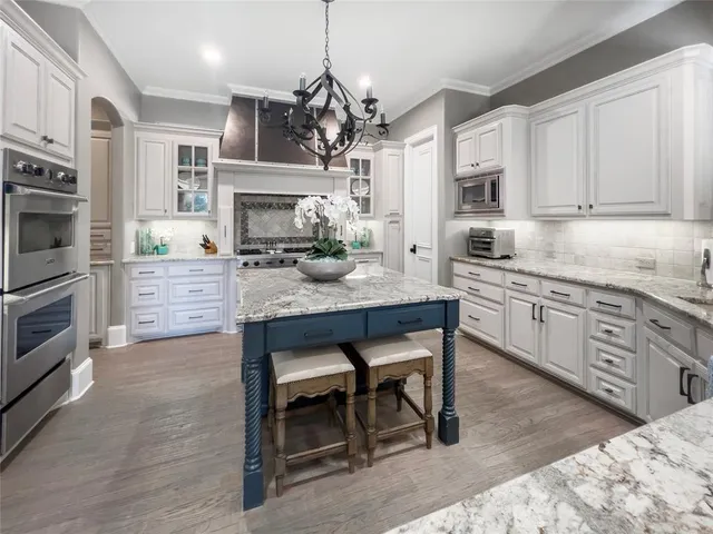 a kitchen with a sink cabinets and wooden floor